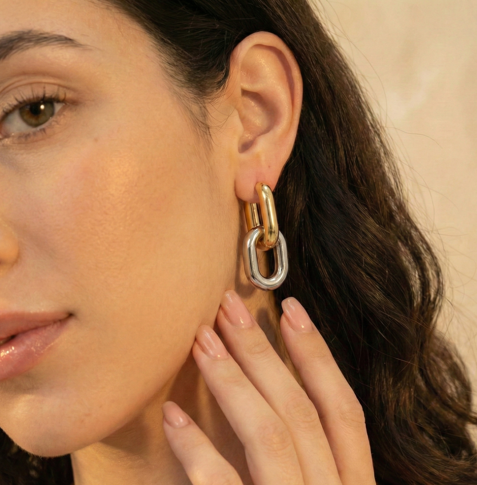 Close-up of a woman wearing a gold and silver hoop earring.