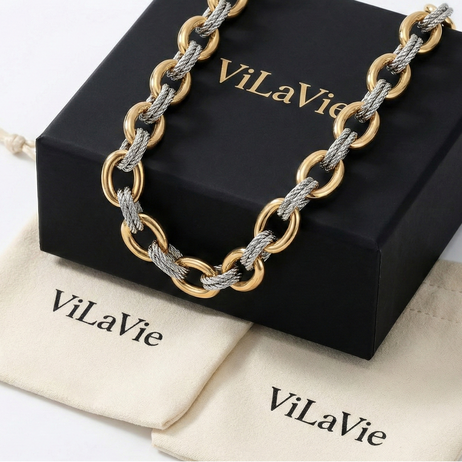 Gold and silver chain bracelet on a black box with 'ViLaVie' branding, on a white background.