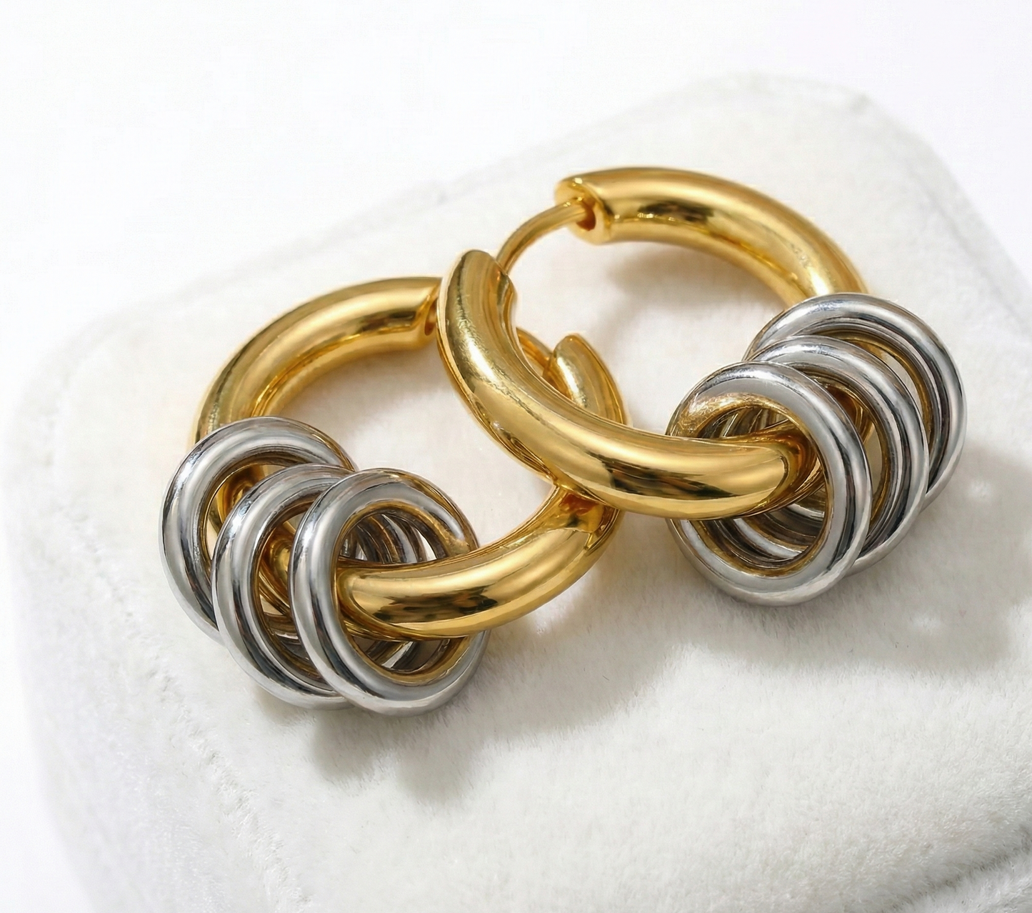 Gold and silver hoop earrings on a white background