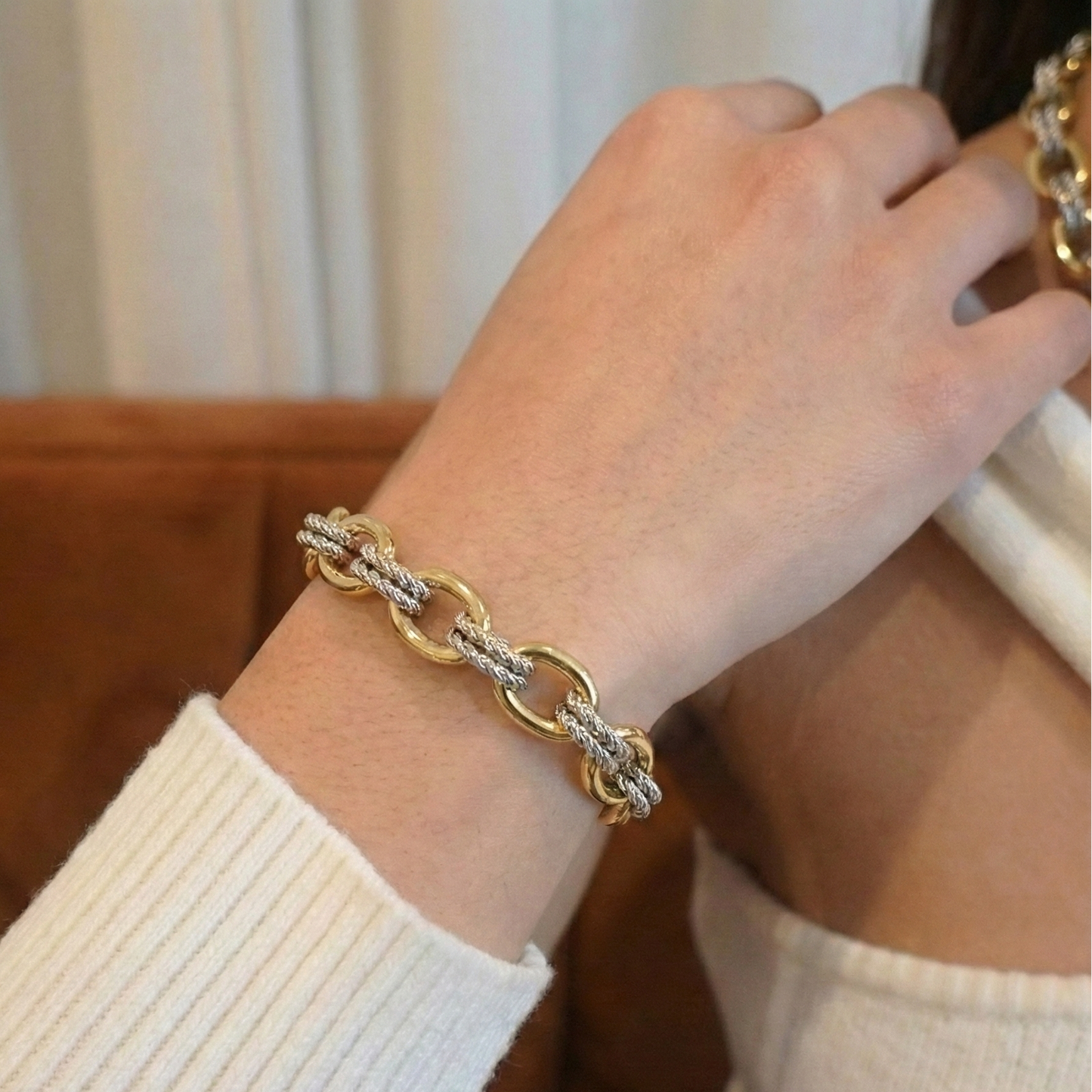 Gold bracelet on a wrist with a blurred background