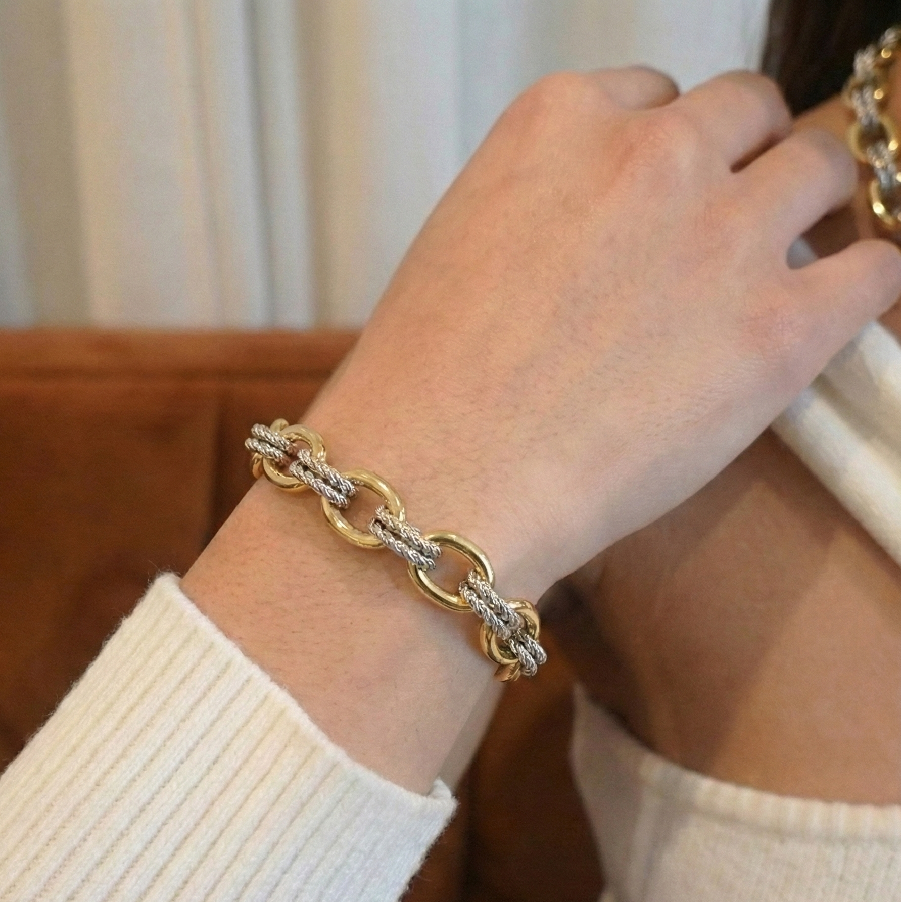 Gold bracelet on a wrist with a blurred background