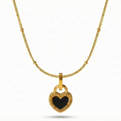 Gold necklace with a heart-shaped pendant on a white background