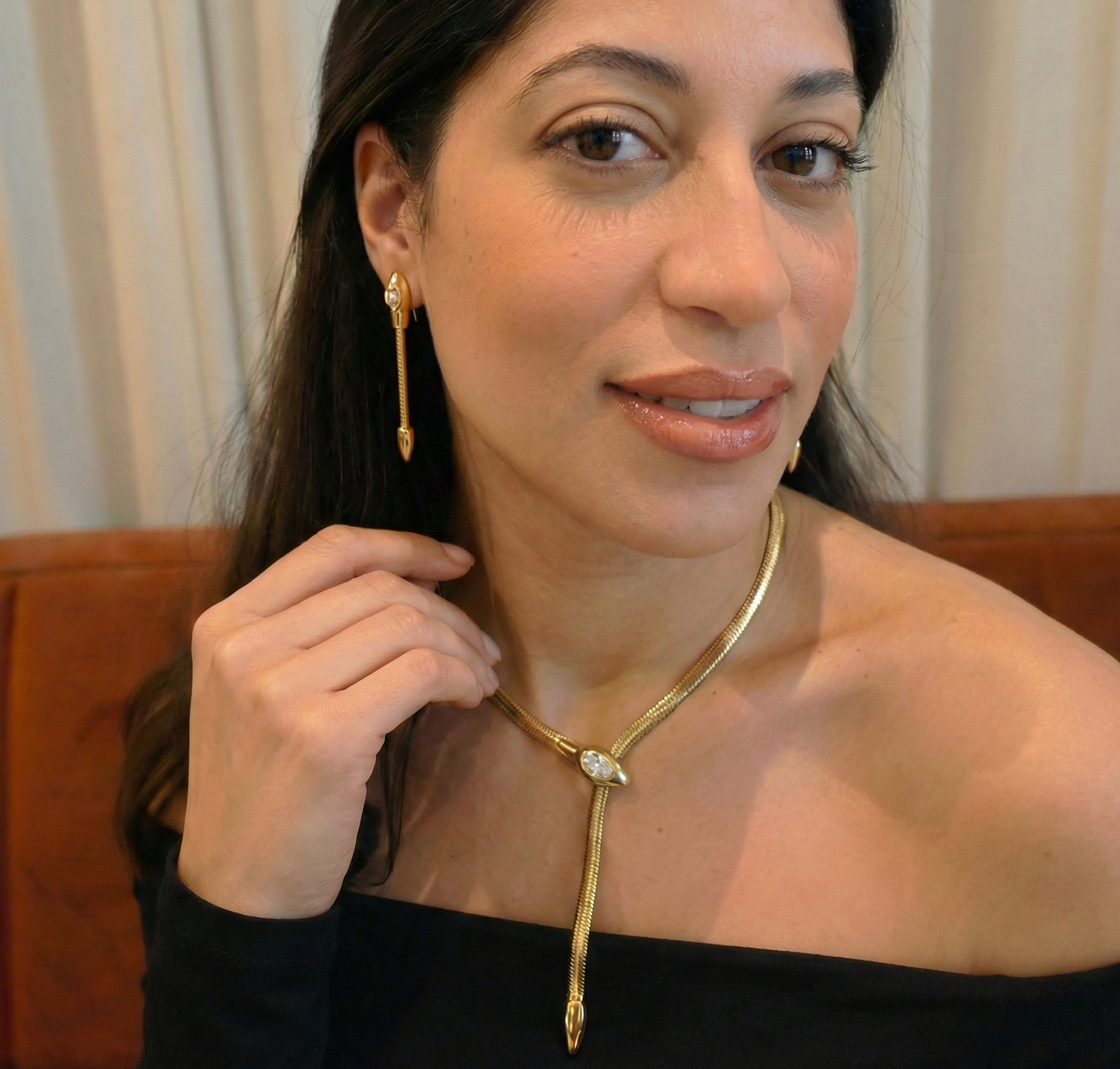 Gold snake necklace with a diamond on a woman's neck