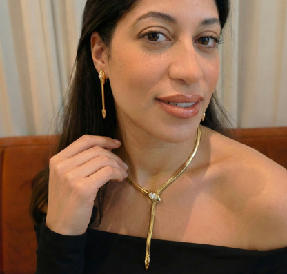 Gold snake necklace with a diamond on a woman's neck