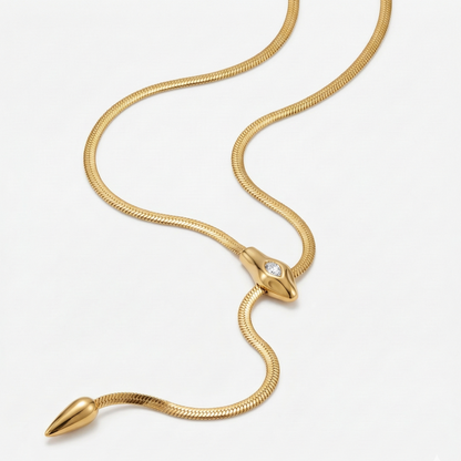 Gold snake-shaped necklace on a white background