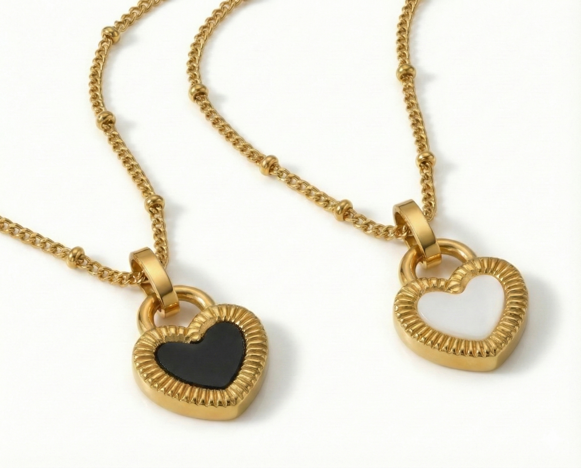 Two gold heart-shaped pendants on a white background