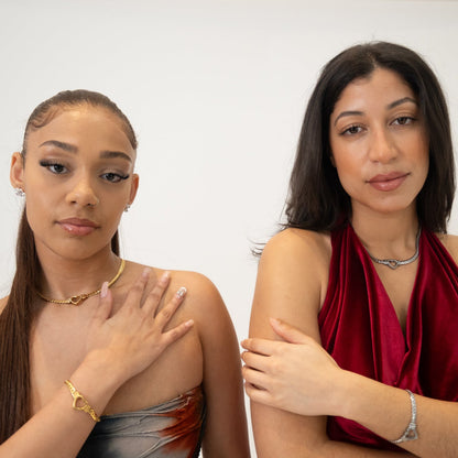 Two women standing side by side against a plain background