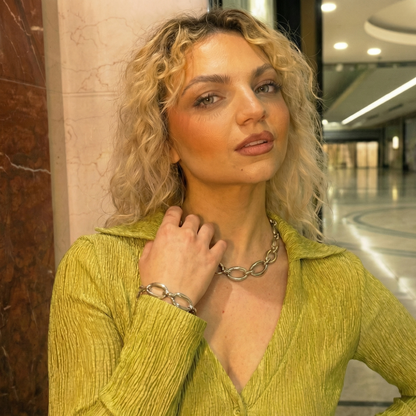 Woman in a green sweater with a blurred indoor background