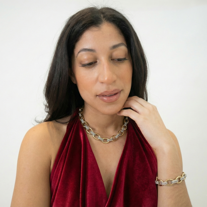 Woman wearing a red dress and gold necklace with a white background